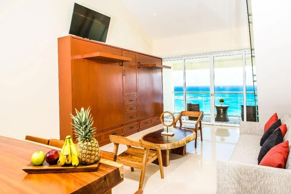 Sala de estar con cama Murphy y vista al mar del Penthouse 3B en Salvia, Cancún