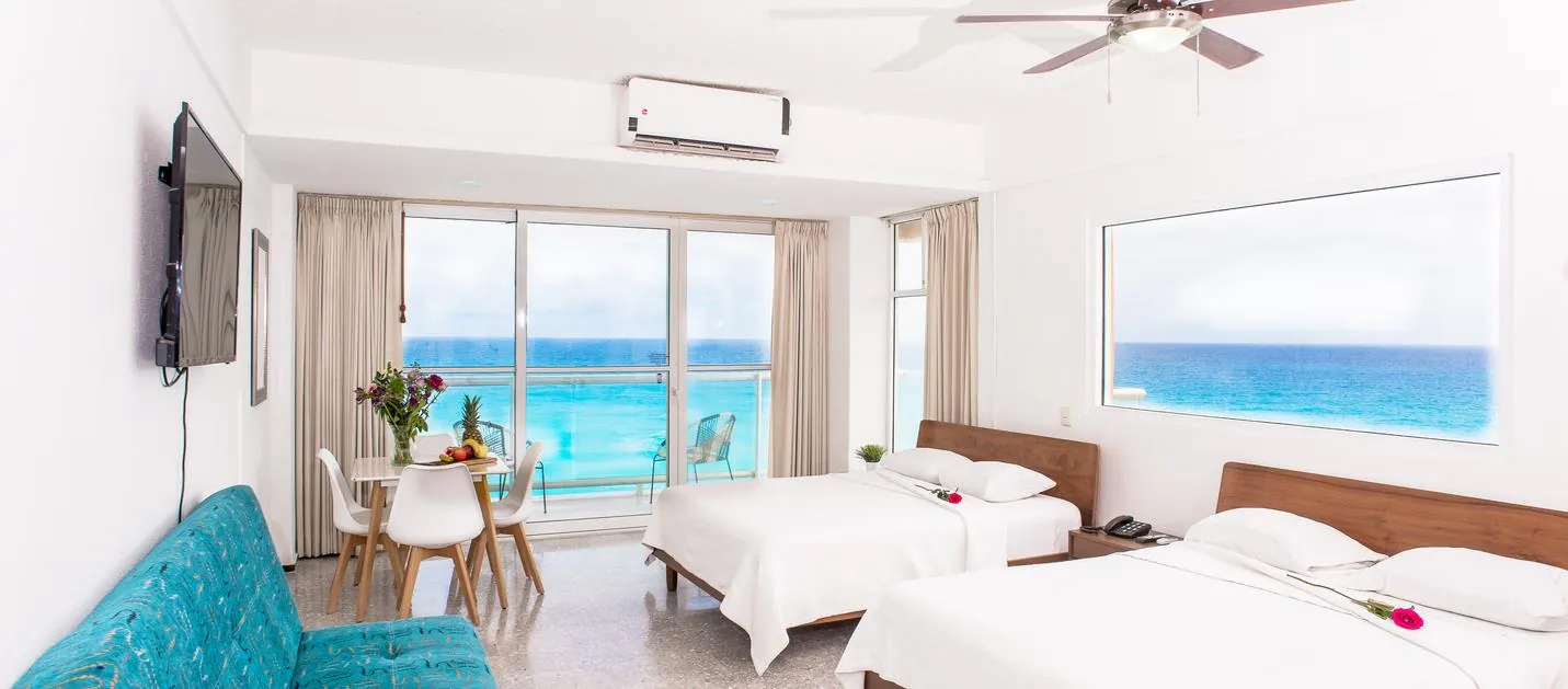 Recámara con dos camas y comedor frente al mar del departamento 604AB en Salvia, Cancún