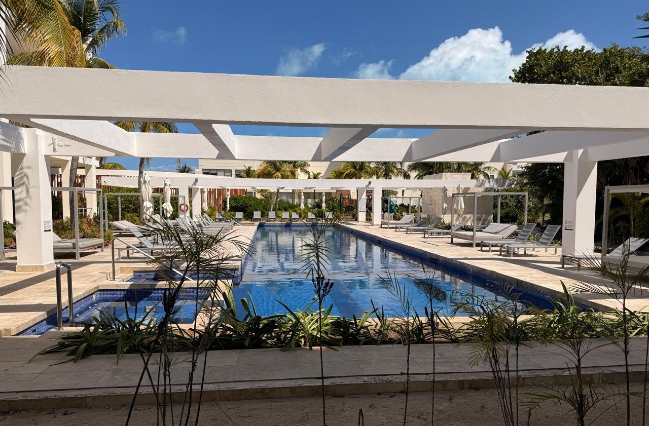 Alberca exterior con camastros y pérgolas en La Amada, Costa Mujeres, Cancún